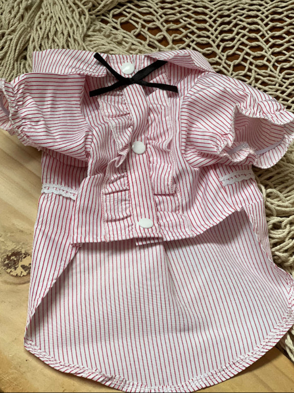 CAMISA DE RAYITAS ROJAS FONDO BLANCO, CON BOTONES A PRESION Y OLANES EN LA PARTE DE ENFRENTE QUE PARECE LAS CAMISAS DE ESMOQUIN. PARA PERRITO O GATITO DE RAZA PEQUEÑA.