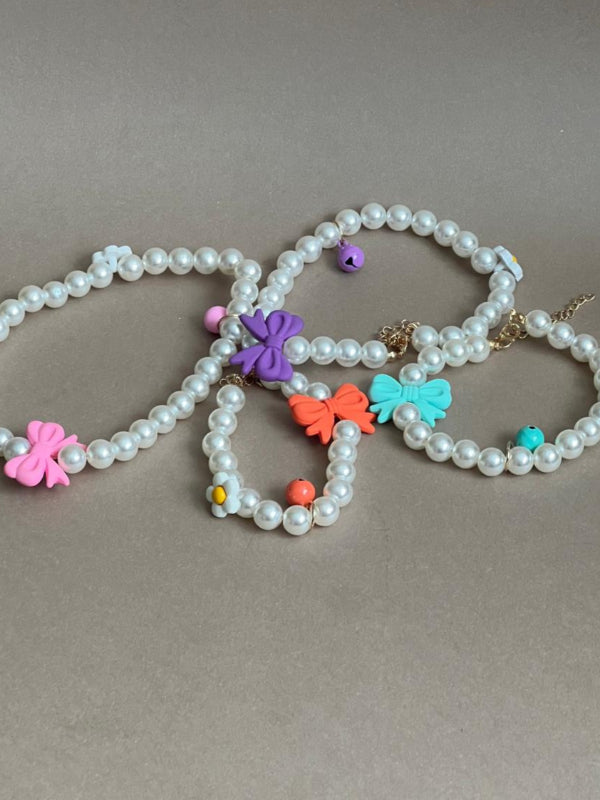 collar para perro de perla (no real) y lazo hecho de plástico. Muy coquetos. No sirve para la correa.