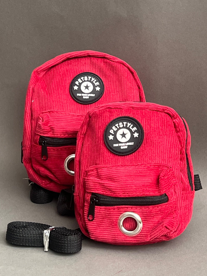 mochila roja para perro de varios colores para que cargue sus premios y bolsitas. Es liviana por lo que no le pesa.