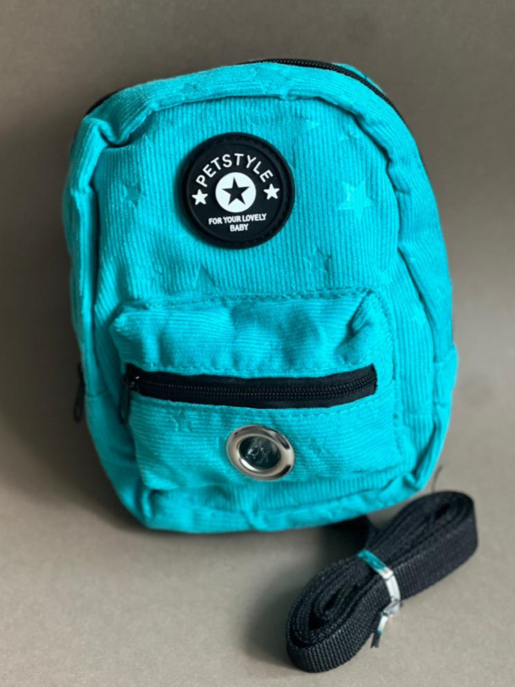 mochila azul para perro de varios colores para que cargue sus premios y bolsitas. Es liviana por lo que no le pesa.