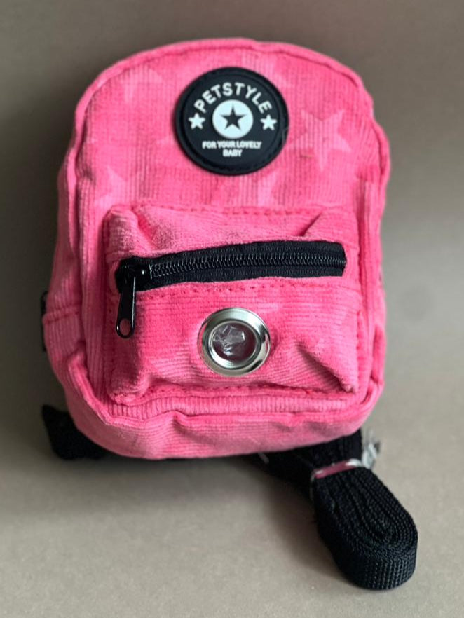 mochila rosa fuerte para perro de varios colores para que cargue sus premios y bolsitas. Es liviana por lo que no le pesa.