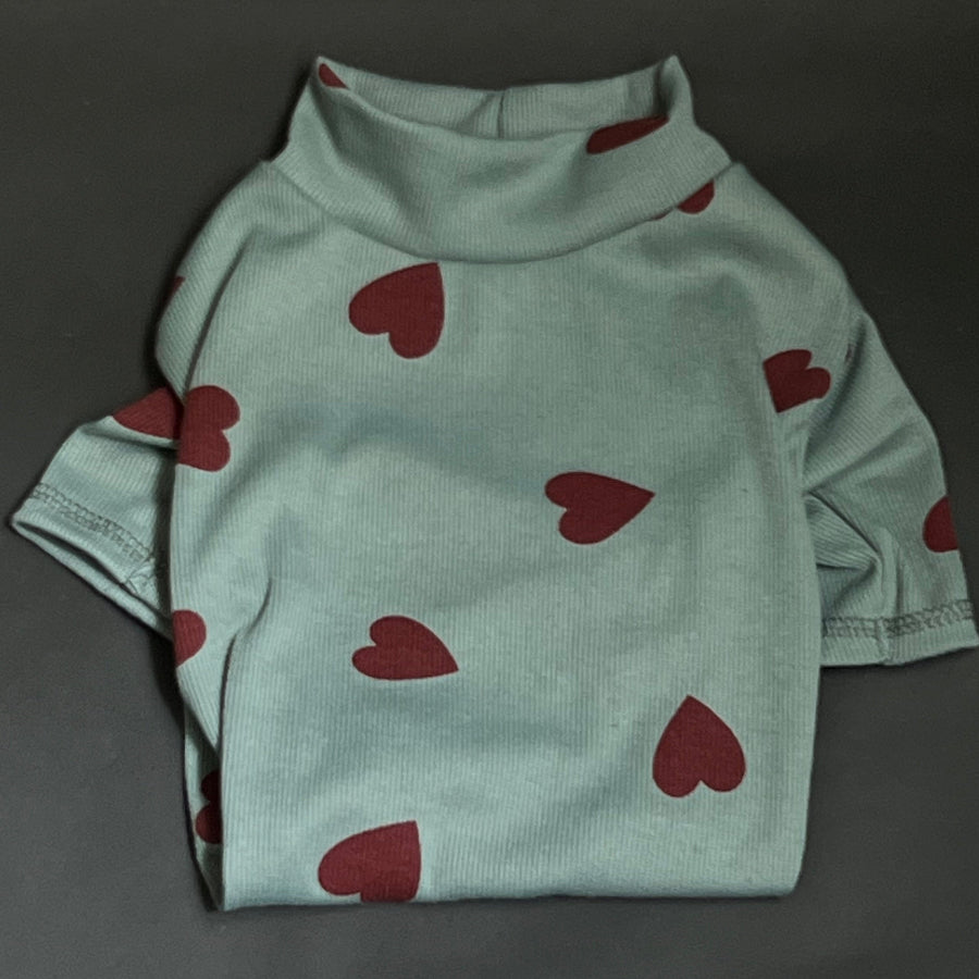 ESTAMPADO DE CORAZONES, CUELLO ALTO PERO NO ES GRUESO. VISTE Y ES COMODO ES SUETER POR LO QUE NO TIENE BOTONES O CIERRE. COLOR VERDE ESTAMPADO CORZONES ROJOS