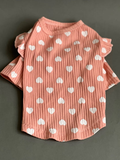 Blusa fresca en color rosa con corazones en color blanco. y coqueta para perro y gato, es còmoda, liviana y tiene olanes en los hombros. viene en tes colores. pararazas pequeñas a medianas.