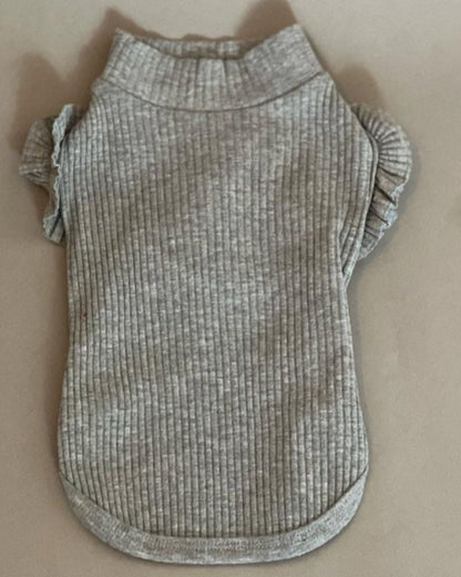 CAMISETA EN COLOR GRIS PARA PERRO O GATO. SUPER COQUETA CON OLANES EN LOS HOMBROS, NO TIENE MANGAS POR LO QUE LA HACE IDEAL PARA EL VERANO. SIMPLEMENTE SE METE POR LA CABEZA PORQUE NO TIENE NI CIERRE NNI BOTONES.