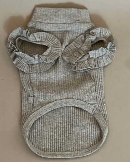 CAMISETA EN COLOR GRIS PARA PERRO O GATO. SUPER COQUETA CON OLANES EN LOS HOMBROS, NO TIENE MANGAS POR LO QUE LA HACE IDEAL PARA EL VERANO. SIMPLEMENTE SE METE POR LA CABEZA PORQUE NO TIENE NI CIERRE NNI BOTONES.