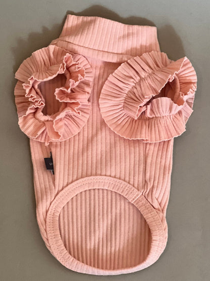 CAMISETA EN COLOR ROSA PARA PERRO O GATO. SUPER COQUETA CON OLANES EN LOS HOMBROS, NO TIENE MANGAS POR LO QUE LA HACE IDEAL PARA EL VERANO. SIMPLEMENTE SE METE POR LA CABEZA PORQUE NO TIENE NI CIERRE NNI BOTONES.