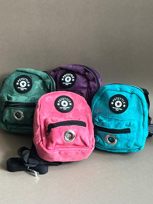 mochila para perro de varios colores para que cargue sus premios y bolsitas. Es liviana por lo que no le pesa.