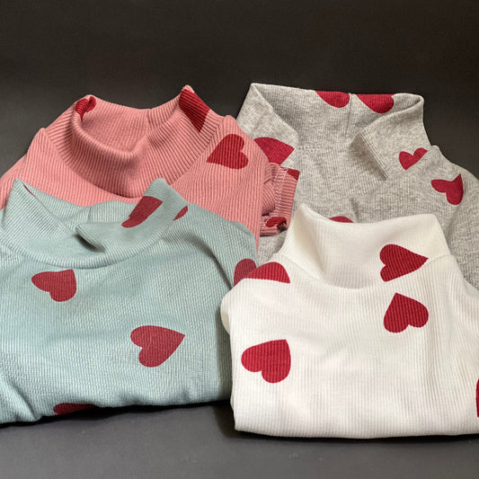 ESTAMPADO DE CORAZONES, CUELLO ALTO PERO NO ES GRUESO. VISTE Y ES COMODO ES SUETER POR LO QUE NO TIENE BOTONES O CIERRE. COLOR GRIS ESTAMPADO CORZONES ROJOS.